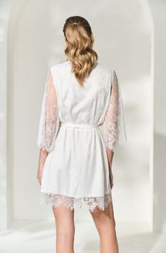 Made in a unique delicate white french lace design, the Lara Lace Robe is the perfect gift for the bride-to-be on her wedding day. Featuring scalloped lace edges along the neckline, hem and sleeve cuffs, this robe exudes old-world elegance. The body of the Lara Robe is fully lined to provide our brides the coverage they need. A slip dress is not required for under this robe, but if you're in search of one we recommend our White Bridal Slip Dress. Material: French lace with a fully lined bodySlee White Lace Bridesmaid Dress With Scalloped Lace, White Scalloped Lace Dress For Bridesmaid, Elegant Lace Dress With Scalloped Lace For Wedding Night, Lace Dress With Lace Cuffs For Wedding Night, Lace Wedding Dress With Lace Cuffs, Elegant Scalloped Lace Dress For Wedding Night, Elegant Lace Dress With Lace Trim For Wedding Night, Wedding Night Lace Patchwork Dress, White Lace Dress With Lace Sleeves For Bridesmaid