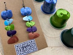 three pairs of colorful wooden earrings sitting on top of a table next to each other