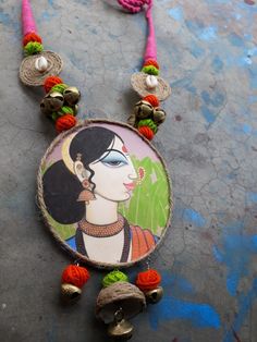 a necklace with an image of a woman on it and beads hanging from the neck