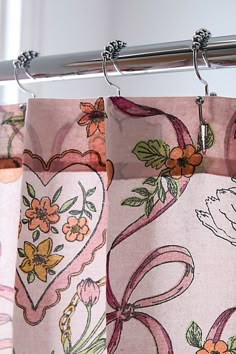 the curtains are hanging in front of the window with flowers and hearts drawn on them