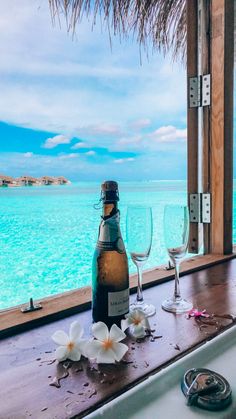 a bottle of wine sitting on top of a counter next to a window overlooking the ocean