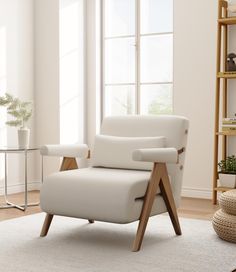 a white chair sitting on top of a rug next to a window