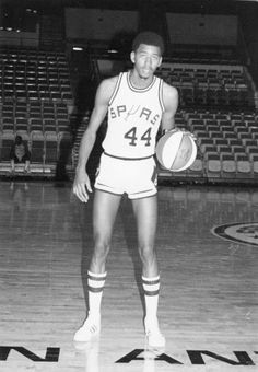 an old photo of a basketball player holding a ball in his hand and standing on the court