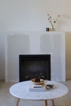 a living room with a fire place and a white table in front of the fireplace