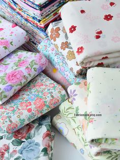 a pile of different colored floral fabric on top of each other in various sizes and colors