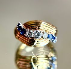 For your consideration, a chic vintage 14K gold diamond and sapphire bombe ring.  The ring is in overall good condition with mild wear and no major condition issues.  Mild abrading to the sapphires, one small sapphire with surface feather inclusions, and mild surface wear to the gold are noted in photos.  The ring is not hallmarked but has a hand engraved serial number so I suspect this is a custom made piece.  The stones test as diamond and sapphire with a presidium gem tester and the gold acid tests at 14K.  The diamonds are bright and eye clean.  **Signature required for delivery.** Size 8.5, weight 9.3 grams.  Diamonds measure 2.75, 3.5, and 4mm and I would guesstimate the total weight at around 35-40 points (I am not a trained gemologist).  The sapphires measure 2, 2.25, and 2.75mm (t Bombe Ring, Dome Ring, Domed Ring, Chic Vintage, Hand Engraving, Vintage Chic, Rings Statement, Statement Rings, Gold Diamond