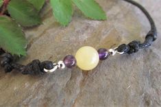 This very cute anklet features an 8mm yellow jade bead accented with 6mm amethyst beads on 1.5mm waxed cotton cord finished with double slider knots making this anklet fully size adjustable down to a minimum of 8 inches. Comfortable, sturdy and easy to wear this style would make a great gift idea. YELLOW JADE SYMBOLISM AND PROPERTIES Yellow jade is said to be a stone of wisdom, helping users to learn from their experiences and gain self-confidence. Yellow as a color also symbolizes warmth and joy. This stone is also believed to affect the digestive system and increase the metabolism and resonates with the solar plexus chakra. Adjustable Natural Stones Bracelet, Elegant Jewelry With Adjustable Cord And Round Beads, Minimalist Adjustable Jewelry For Meditation, Adjustable Waxed Cord Jewelry For Everyday, Minimalist Amber Jewelry For Healing, Adjustable Spiritual Waxed Cord Jewelry, Casual Waxed Cord Jewelry For Everyday, Casual Everyday Waxed Cord Jewelry, Beaded Waxed Cord Bracelet