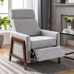 a gray recliner chair sitting on top of a rug