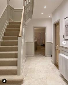 a staircase leading up to the second floor in a house with beige carpet and white walls