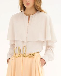 Chloe Pristine White Long Sleeve Layered Blouse Round neck Cape overlayer Long sleeves; button cuffs Concealed button down front closure Relaxed fit 100% silk Designer Long Sleeve Blouse With Blouson Sleeves, Designer Blouse With Blouson Sleeves, Feminine Silk Button-up Blouse, Elegant Silk Blouse With Covered Buttons, Luxury Blouse With Blouson Sleeves For Spring, Luxury Long Sleeve Spring Blouse, Elegant Long Sleeve Silk Crepe Blouse, Luxury Long Sleeve Blouse For Spring, Timeless Silk Blouse For Daywear