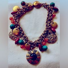 This Light Weight, Double Chain, Gold Plated Charm Bracelet Shows Off 23 Different Stones And Gold Charms, Including Turquoise, Hessonite, And Topaz Colored Beads, Intermixed With Gold Tone Charms, With The Center Largest Charm Featuring A Tigerseye Bead. Bracelet Closes With A Gold Charm Magnet Clasp, As Shown In Photos. Bracelet Measures 7.5 Inches Long. Bracelet Is In Excellent Condition, Like Brand New. Please Try To Bundle And Save On Shipping. Bohemian Multicolor Metal Charm Bracelet, Bohemian Style Multicolor Metal Charm Bracelet, Bohemian Round Charm Bracelet For Jewelry Making, Bohemian Metal Chain Bracelet With Adjustable Chain, Bohemian Metal Chain Bracelet, Nickel-free Metal Bohemian Chain Bracelet, Bohemian Metal Beaded Bracelets With Adjustable Chain, Handmade Bohemian Round Charm Bracelet, Bohemian Beaded Metal Charm Bracelet