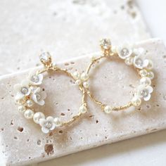 For the modern bride, these KARA floral hoop earrings will give your look a touch of classic elegance with a pop of glimmering gold and pearlescent charm! Show off your bridal beauty with these gorgeous earrings - the perfect finishing touch for your special day! - Handcrafted with genuine Austrian crystals and pearls- Clear crystals- Polymer clay flowers- Available yellow gold or rhodium (silver)- Earrings measure 1.5 x 1.5 inches- Handcrafted in the US.- Nickel free and hypoallergenic- PLEASE Earrings For Bride, Earrings With Pearls, Floral Hoops, Polymer Clay Flowers, Gold Cream, The Modern Bride, Clay Flowers, Bridal Beauty, Clear Crystals