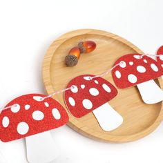 a wooden plate topped with red and white mushrooms