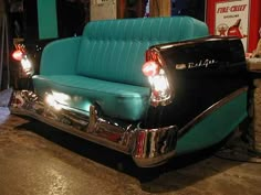 an old fashioned car is parked in a garage with its hood up and lights on