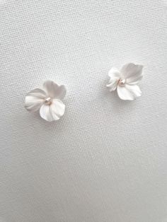 These lovely floral stud earrings are handcrafted with delicate polymer clay flowers and adorned with freshwater pearls. They are attached to sterling silver or gold-filled studs for a touch of elegance. Sent beautifully packaged in Medze Bride gift box. As 'Dreamy White' earrings are made to order as well due to hygienic reasons I cannot accept refunds/exchanges. But if you have any problems with your order please email me and I'll be happy to help you. Handle with care due to the handcrafted n Delicate Pearl White Flower Earrings, Delicate White Jewelry With 3d Flowers, White Dainty Flower Bridal Earrings, Pearl White Jewelry With 3d Flowers For Wedding, Pearl White Wedding Jewelry With 3d Flowers, Hypoallergenic Sterling Silver Flower Earrings For Wedding, Minimalist White Bridal Earrings For Wedding, Delicate White Flower Earrings, Flower Shaped Pearl Earrings With 3d Flowers As Gift