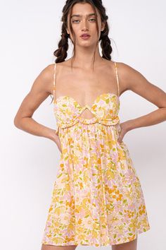 The Drew Peach Floral Babydoll Cami Mini Dress is here for sunshine and fun summer days! White, peach, and yellow floral fabric forms this cute floral bralette babydoll dress with cami straps and a bralette cutout bodice. The attached mini skirt falls from an empire waist. A ruffle back with ties finishes the look! Style with cute sandals for a fun summer look! DETAILS & CARE 100%Rayon. 100% Polyester Lining. Machine wash cold. Imported. Spring Feminine Mini Dress With Built-in Bra, Spring Mini Dress With Built-in Bra, Spring Sundress With Spaghetti Straps And Built-in Bra, Spring Dresses With Sweetheart Neckline And Built-in Bra, Spring Mini Dress With Built-in Bra For Brunch, Spring Brunch Dresses With Built-in Bra, Feminine Summer Sundress With Sweetheart Neckline, Spring Vacation Dresses With Built-in Bra, Spring Peach Dress With Spaghetti Straps