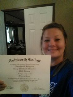 a woman holding up a certificate in front of a door