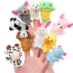 a hand that has many small stuffed animals on it