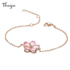 a pink flower bracelet on a chain with the words thaya written in arabic and english