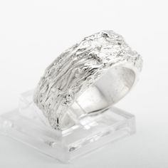 This "Fiji" silver ring is handmade in Fine Silver (99.9% pure silver). This unique piece is entirely molded by hand, using the silver clay technique. The style of this ring is inspired by the beauty of the most amazing coral reefs in the world. Ring size: 7.25 (This is a unique creation. Only one size available. I cannot adjust the ring size.) What is Fine Silver? Fine Silver, also called Precious Metal Clay or Silver Clay, is a malleable material composed of microscopic particles of pure silver. It is made from silver that is recycled from a range of sources, including waste from x-rays and the photographic industry. It can be worked like traditional clay using the hands, or else molded. The molded piece is then heated to merge the fine silver particles together. The result is a 99.9% pu Sterling Silver Carved Promise Ring, Hand Cast Sterling Silver Wide Band Jewelry, Unique Carved Sterling Silver Rings, Hand Cast Wide Band Silver Sterling Ring, Hand Cast Sterling Silver Wide Band Ring, Carved White Gold Ring, Hand Cast Sterling Silver Engraved Ring For Wedding, Gift White Gold Hand Cast Ring, Unique Carved Silver Rings