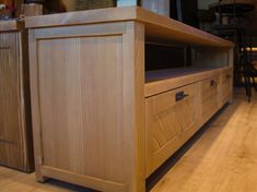 a wooden entertainment center sitting on top of a hard wood floor next to a bar