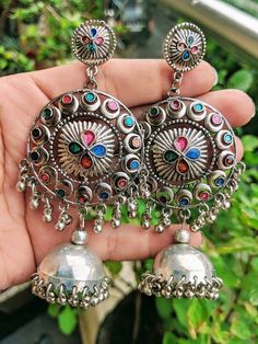 Add charm and charisma to your beautiful personality with these exquisitely handcrafted Afghani earrings jhumkas made with high quality German Silver. The intricate design and the glass enamel work renders these earrings a very unique and classy look. Pair them up with any formal or casual attire and gather compliments all the way!Weight  36 gmLength 4 inches Width 1.8" inches Traditional Multicolor Round Hoop Earrings, Traditional Multicolor Hoop Earrings, Multicolor Chandbali Jhumkas For Navratri, Navratri Multicolor Chandbali Jhumkas, Fusion Style Danglers With Latkans For Navratri, Navratri Dangle Jhumkas, Fusion Style Dangle Jhumkas With Latkans, Fusion Style Dangle Jhumkas For Festivals, Multicolor Latkans Jhumkas For Navratri