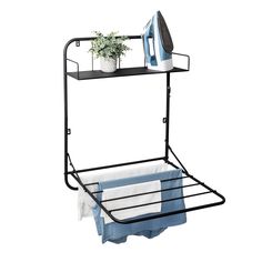 an ironing rack with two towels and a potted plant