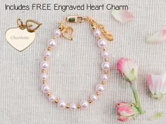 Personalized with FREE engraved heart charm this timeless bracelet is made with pink high-end simulated Austrian pearls and 14K Gold-plated beads (over sterling silver) accented with a beautiful dainty accent heart embellished with sparkling CZs!  This trendy high quality bracelet is available in three sizes for infants, babies, toddlers, and kids.  This bracelet makes a sweet Valentines gift, baby gift, or something special for your granddaughter and comes in a beautiful gift box ready for gift Personalized Pink Jewelry For Mother's Day, Personalized Pink Birthstone Jewelry, Pink Jewelry For Mother's Day Personalized Gift, Mother's Day Personalized Pink Jewelry Gift, Pink Heart Charm Bracelet As A Gift, Pink Heart Charm Bracelet For Gift, Pink Heart Charm Bracelet As Gift, Dainty Pink Heart Charm Bracelet, Personalized Pink Charm Bracelet For Valentine's Day