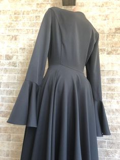 the back of a dress with long sleeves and flared hems, on a mannequin head