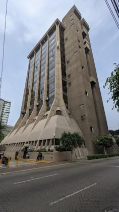 a tall building with many windows on the side of it's face in front of a city street