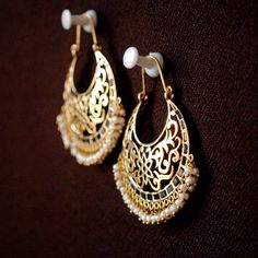 "Intricate filigree in a crescent moon frame, adorned by gorgeous blue stones and finished by tiny dangling pearls, these gorgeous earrings are the only accessory you will need! ) * Gold - 14k, 13.5 gms yellow gold * Style - Hoop * Gems - Blue crystal and pearls * Dimension - 2.2\" x 1.5\" (approx.) Chandelier - Gold Hoop Earring - Chand Bali - Big Wedding Earring If you like these earrings, please press \"Pin it\" button on the right of your screen. Find us on Instagram for exquisite designs: @ Bali Designs Earings, Chand Bali Earrings, Moon Frame, Chand Bali, Pin It Button, Chandelier Gold, Gold Hoop Earring, Bali Earrings, Wedding Earring