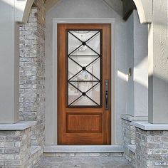 a black front door with an arched glass window on the side of a brick building