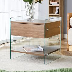 a vase with flowers sitting on top of a glass table next to a book shelf