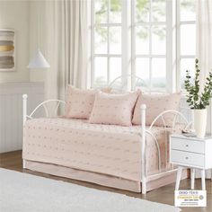 a white daybed with pink bedding and pillows