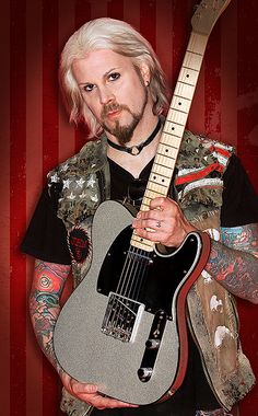 a man holding a guitar in front of a red and black background with the words john 5 on it