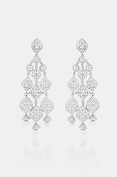 Introducing exquisite long Diamond dangler earrings, adorned with shimmering faux diamonds and graceful pearl drops, set against a pristine white finish. This statement piece exudes elegance and adds a touch of ravishing allure to any ensemble. Finish: Rhodium Material: Brass, Faux Diamonds, Pearls Color: White Size: One Size Closure Type: Push Back Box Contains: 1 Pair of Earrings Elegant White Drop Chandelier Earrings, Classic White Drop Chandelier Earrings, Elegant White Diamond Earrings For Party, Elegant Diamond Chandelier Earrings For Reception, Elegant Pearl Drop Chandelier Earrings For Reception, Glamorous White Bridal Earrings With Diamond Accents, White Bridal Earrings With Diamond Accents For Evening, Luxury Bridal Earrings For Reception, Luxury White Linear Earrings For Formal Occasions