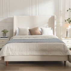 a white bed sitting in a bedroom on top of a hard wood floor