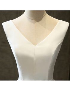 the back of a white dress on a mannequin headdress, with an open v - neckline