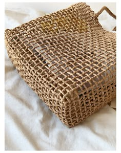 a woven bag sitting on top of a bed