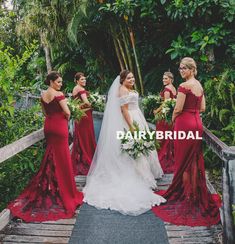 the bride and her bridesmaids are standing on a bridge