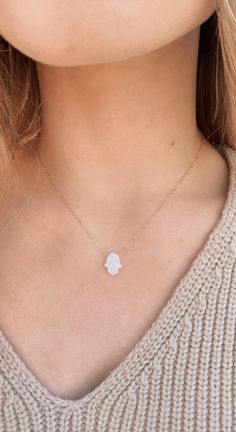 Embrace ocean-inspired elegance with our Iridescent Opal Hamsa Hand Necklace! Featuring a shimmering opal resin Hamsa charm in your choice of turquoise or white, this dainty yet meaningful piece symbolizes protection, good fortune, and positive energy. Suspended on a 14k gold-plated, 14k gold-filled, or silver-plated chain, it’s perfect for layering or wearing solo to add a subtle coastal glow to any outfit. A must-have for beach lovers and free spirits alike! Necklace is 16 inches in length and Celestial Turquoise Necklace For Gift, Turquoise Shell-shaped Necklace For Gift, Opal Resin, Spiritual Nickel-free Turquoise Necklace Gift, Opal Hamsa Necklace, Multicolor Turquoise Pendant Necklace, Spiritual Style, Hamsa Charm, Resin Charms, Affordable Jewelry