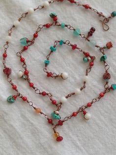 This convertible strand of Coral, Shell, Ruby Jade, Turquoise, Jasper, Crystal and Czech Glass can be worn in several ways including as a bracelet! Hook the strand at any length that suits you. I wrapped each little gem meticulously with pure antiqued copper wire.  Dainty yet sturdy. Can definitely be worn with any style of fashion that is your favorite. Feminine bohemian beauty. Both classic and artistic. As I always say...Enjoy your wardrobe! Turquoise Hand Wrapped Necklaces For Beach, Turquoise Hand Wrapped Necklace For Beach, Handmade Adjustable Lariat Bracelets, Adjustable Bohemian Lariat Bracelets, Gemstone Beads Bracelet Jewelry For Beach, Bohemian Wrap Bracelet With Gemstone Beads For Festivals, Handmade Double Strand Bohemian Jewelry, Handmade Bohemian Double Strand Jewelry, Adjustable Bohemian Lariat Bracelet