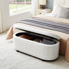 a bed with an open storage compartment underneath it on top of a carpeted floor