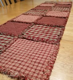 a red and white checkered table runner on a wooden floor with chairs in the background