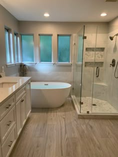 a large bathroom with a tub, sink and shower stall in it's corner