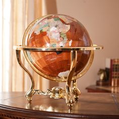 an antique globe sits on a stand in front of a window