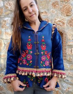 This gorgeous jacket started with a vintage hand embroidered Hungarian felt vest, completely handmade. We have embellished it by adding sleeves, lining and adding vintage trims. We also attached a peplum to make the jacket longer and more fun. We added beautiful brass hooks to close the jacket. The jacket is made of a deep blue wool (100% natural wool) the lining is a very sweet blue taffeta. Although it is vintage, the vest had clearly never been used.  It is of a nice weight, perfect for Fall Fitted Folk Style Embroidered Outerwear, Fitted Embroidered Folk Outerwear, Traditional Blue Floral Embroidered Outerwear, Embroidered Long Sleeve Outerwear For Costume, Traditional Embellished Outerwear For Fall, Folk Style Blue Outerwear For Fall, Blue Folk Style Outerwear For Fall, Blue Folk Style Fall Outerwear, Traditional Embellished Spring Outerwear