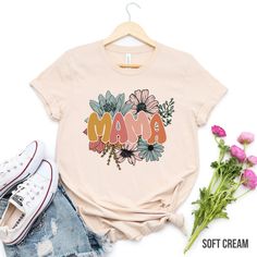 "Retro floral Mama t-shirt, mom shirt for Mom for Mother's Day, Mama T-shirt, Shirt for Mom for Mother's Day, Mama t-Shirt ❤️ Product Details: solid color unisex tees are super soft ring-spun cotton heather tees are a soft cotton-poly blend light fabric (4.2 oz/yd²) loved by all name brand Bella+Canvas runs true to size in a loose fit excellent quality print ❤️ HOW TO ORDER T-SHIRT 1-) Please, Check and Review all Photos. 2-) Select Your T-shirt Size. 3-) Click ADD TO CART and You can go back to add more product color and text color or You can complete the checkout process. 4-)Please Click \"Proceed to Check Out\" 5-) Finally, Your Custom Shirt will be ready to ship 2-4 Business Day. ❤️ SIZING Please reference our sizing chart in the photos to ensure correct size selection. Size down on th Pink Graphic Print T-shirt For Mother's Day, Mother's Day Floral Print Crew Neck T-shirt, Mother's Day Pink Graphic Tee, Pink Graphic T-shirt For Mother's Day, Pink Casual T-shirt For Mother's Day, Pink Funny Print T-shirt For Mother's Day, Funny Print Crew Neck Top For Mother's Day, Family Matching T-shirt With Graphic Print For Mother's Day, Mother's Day Shirt With Custom Print And Relaxed Fit