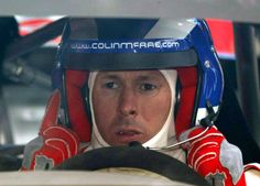 a man sitting in a car wearing a helmet