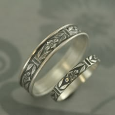 two silver rings with floral designs on them